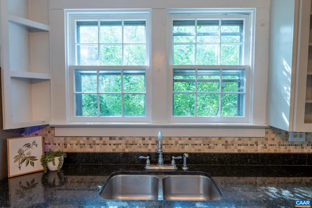 a view of a livingroom with a window wooden floor and a ceiling fan