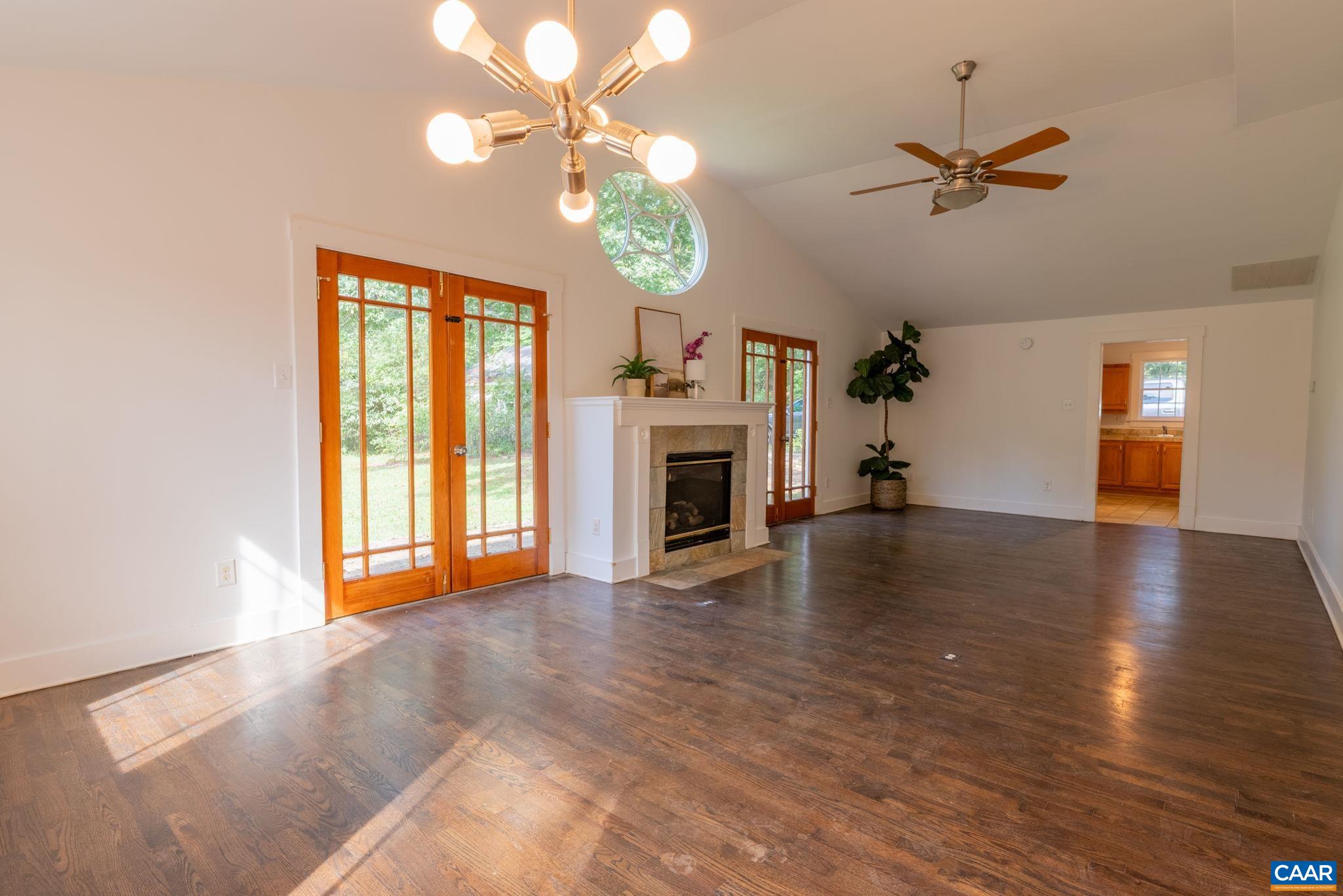 2514 Taylors Gap Road North Garden, VA 22959 - Photo 23 of 75 a view of a livingroom with a fireplace a ceiling fan and wooden floor