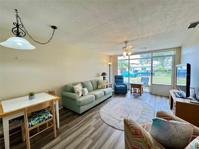 a living room with furniture a flat screen tv and a large window