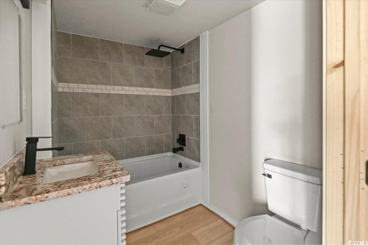 446 Sonny Road Gresham, SC 29546 - Photo 12 of 40 Bathroom featuring toilet, shower / bathtub combination, visible vents, wood finished floors, and vanity