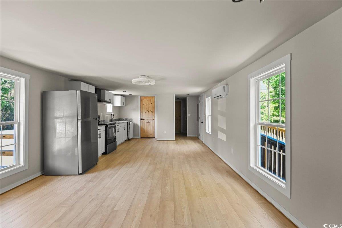 446 Sonny Road Gresham, SC 29546 - Photo 7 of 40 Kitchen with black electric range oven, light wood finished floors, a wall mounted AC, and freestanding refrigerator