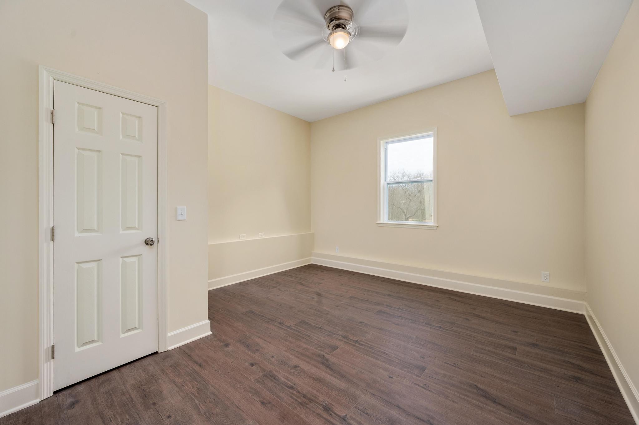 157 Lena Loop Burns, TN 37029 - Photo 15 of 49 an empty room with wooden floor chandelier fan and windows