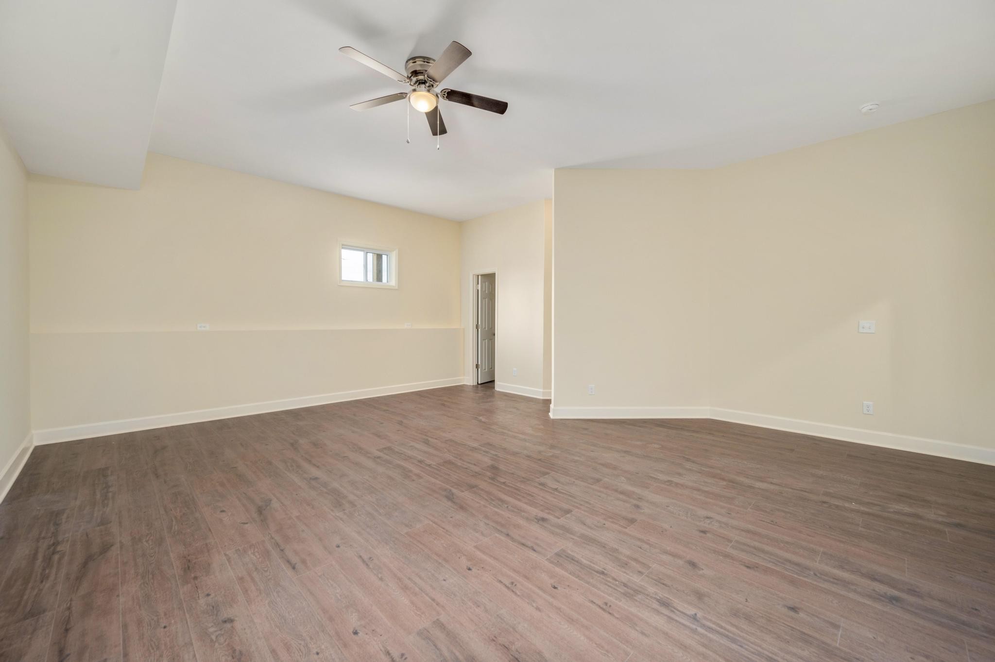 157 Lena Loop Burns, TN 37029 - Photo 21 of 49 a view of an empty room with wooden floor and a ceiling fan