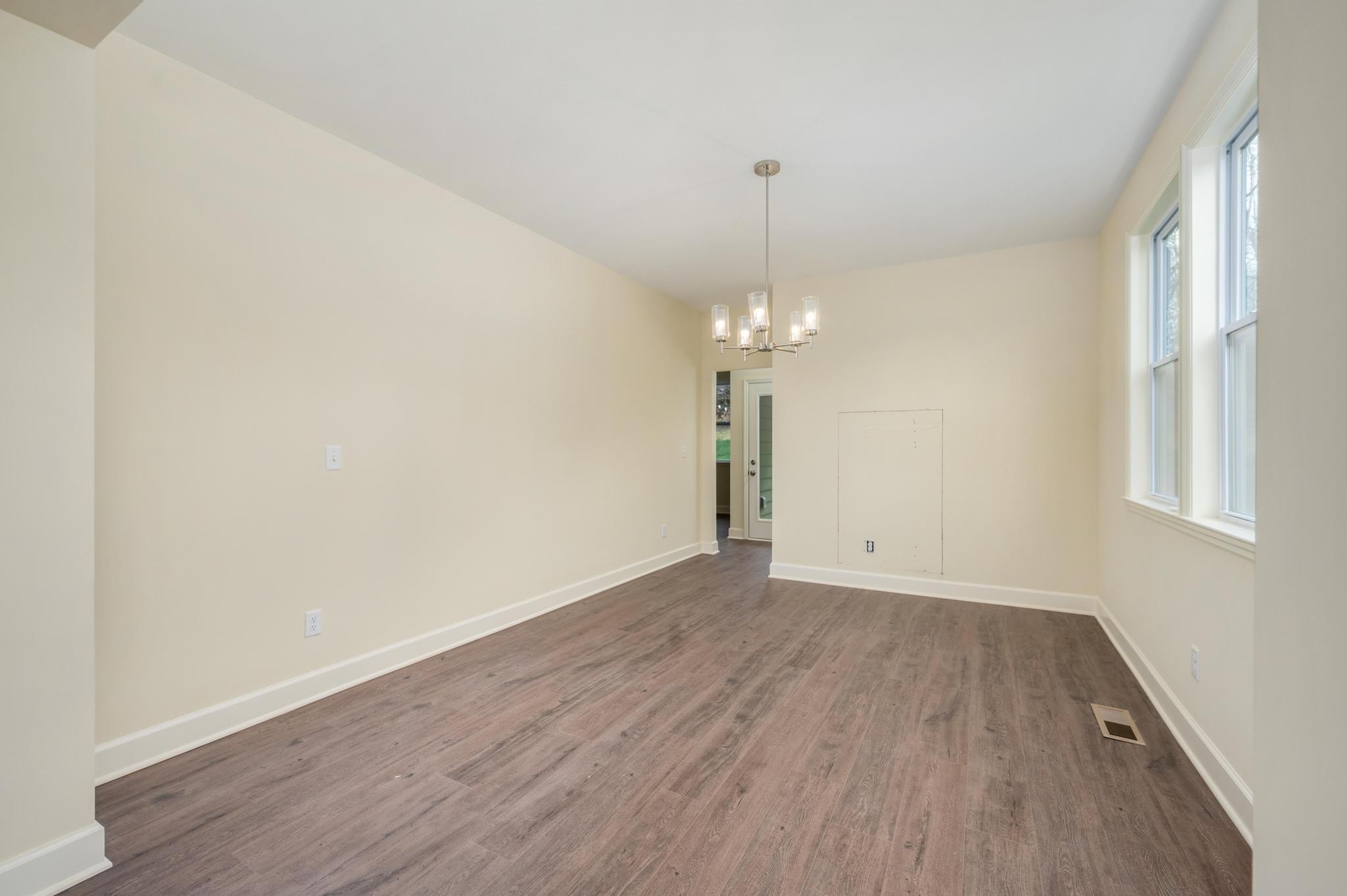 157 Lena Loop Burns, TN 37029 - Photo 7 of 49 a view of empty room with wooden floor chandelier and window