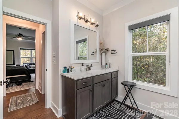a en suite bathroom with a sink a mirror and a window