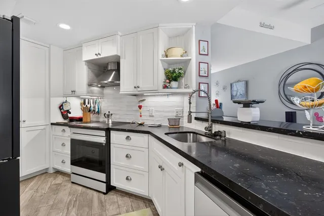 a kitchen with granite countertop a sink stainless steel appliances and cabinets