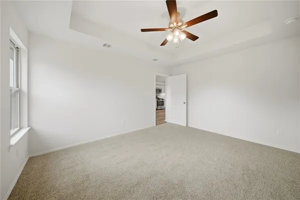 an empty room with closet and fan