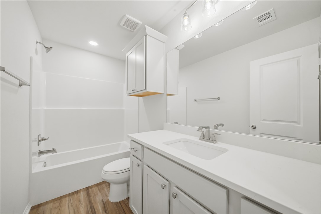 1220 High Street Navasota, TX 77868 - Photo 21 of 27 a bathroom with a sink a toilet and a large mirror