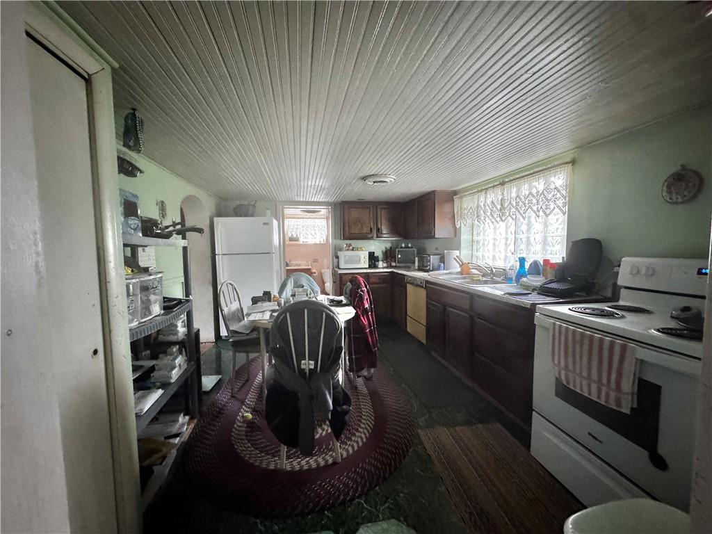 165 Low Hill Road Brownsville, PA 15417 - Photo 18 of 29 a kitchen with a sink a stove a refrigerator cabinets and a dining table