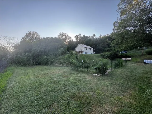 a view of a field with trees in the background