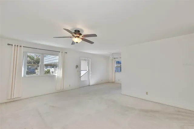 an empty room with closet and a ceiling fan