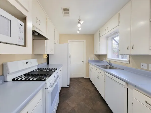a kitchen with stainless steel appliances a sink stove and cabinets