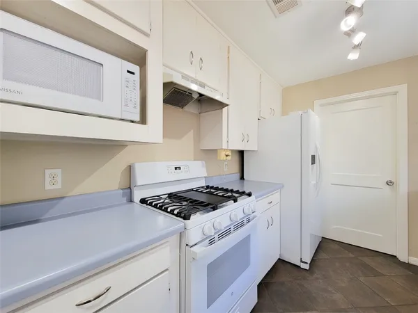 a kitchen with cabinets and a stove top oven