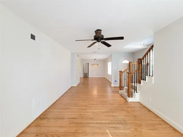a view of a hallway with wooden floor and entryway