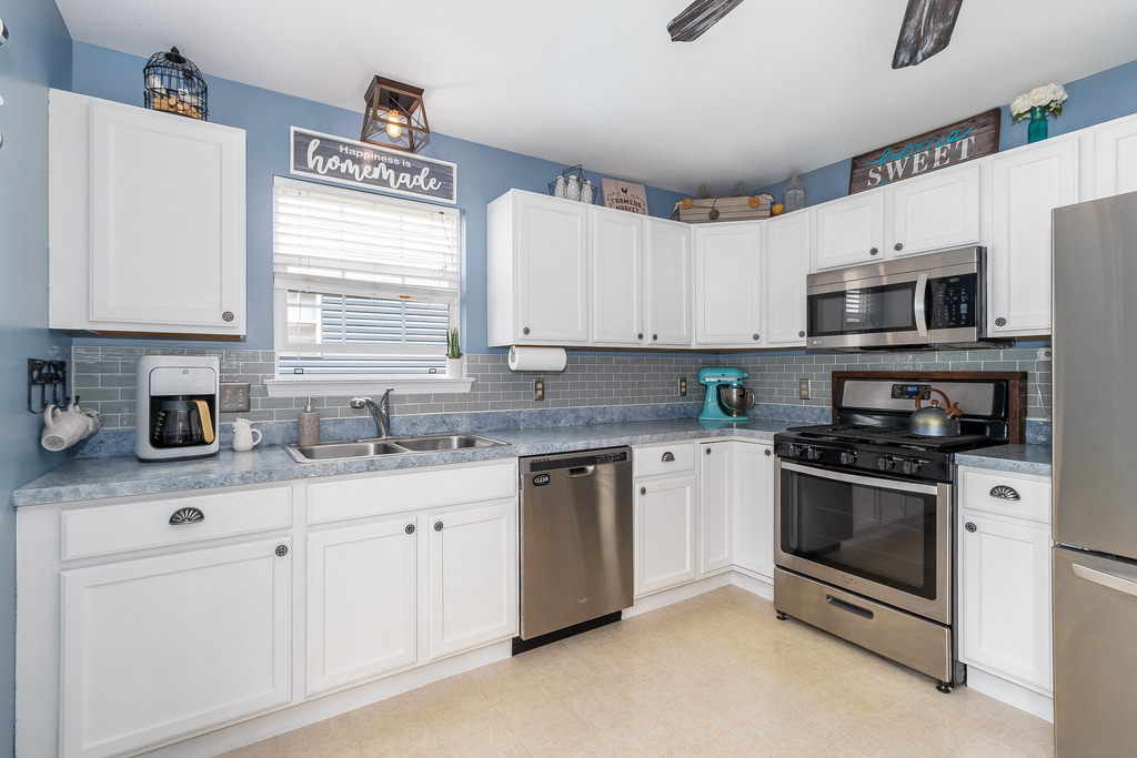 1950 Lakeside Drive Montgomery, IL 60538 - Photo 5 of 15 a kitchen with stainless steel appliances granite countertop a sink a stove a microwave a refrigerator a window and cabinets