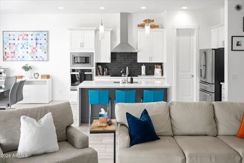 a living room with furniture a kitchen view and a fireplace