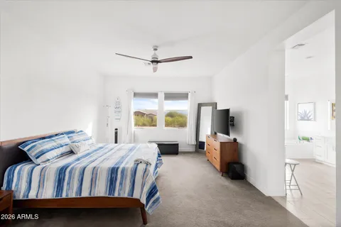 a bedroom with a large bed a flat tv screen and a dresser