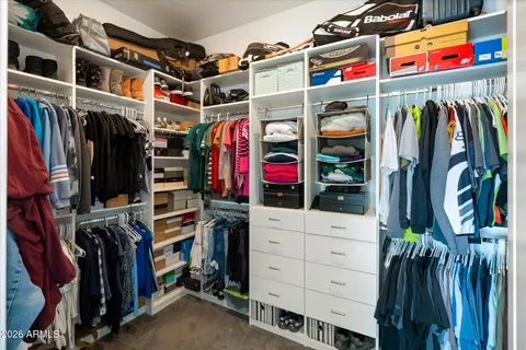 a view of walk in closet with clothes and shoes