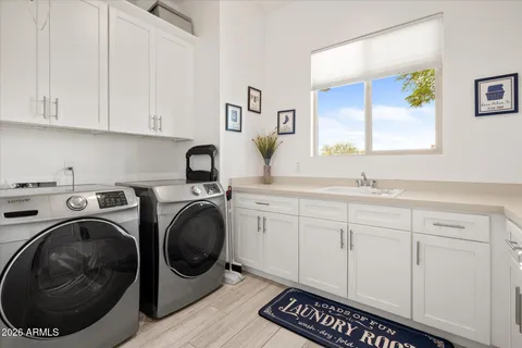a utility room with sink dryer and washer