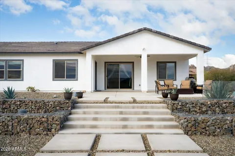 a front view of a house with glass windows and couches