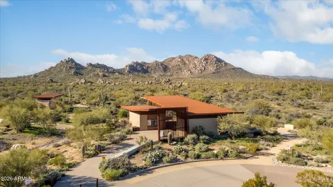 a front view of a house with a yard and mountain view in back