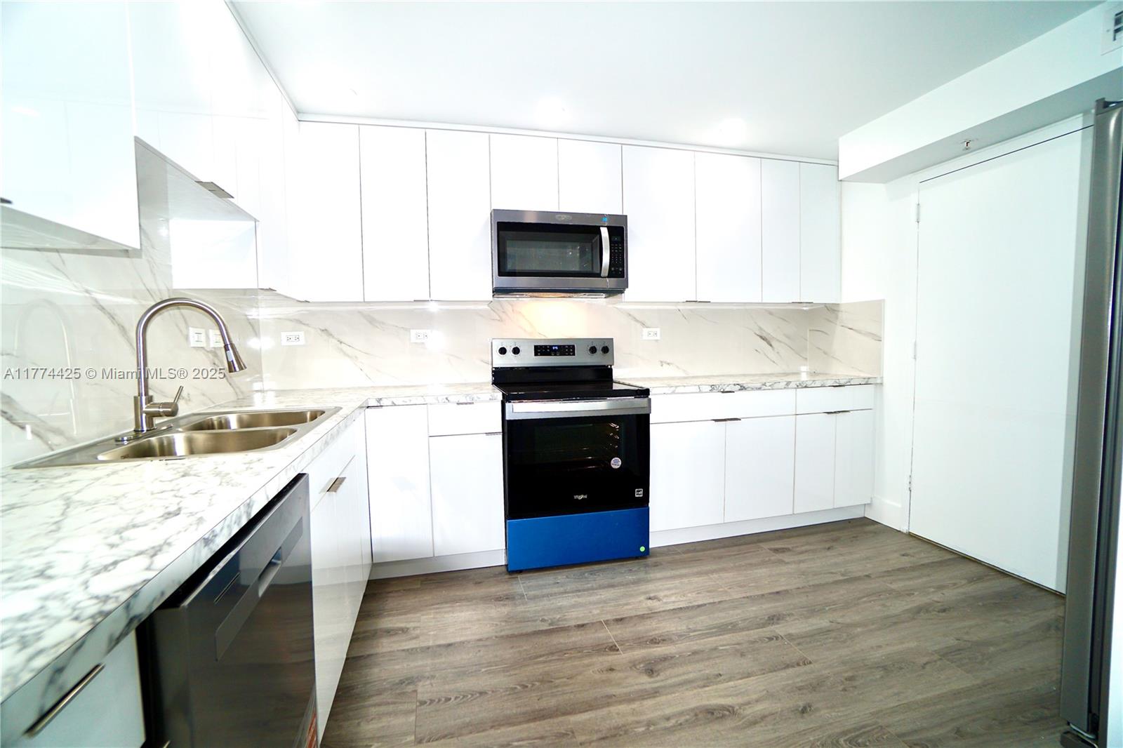 2750 Northeast 183rd Street, Unit 2304 Aventura, FL 33160 - Photo 4 of 12 a kitchen with a sink stove and microwave