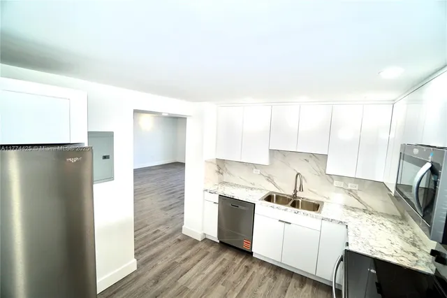 a kitchen with white cabinets and white appliances