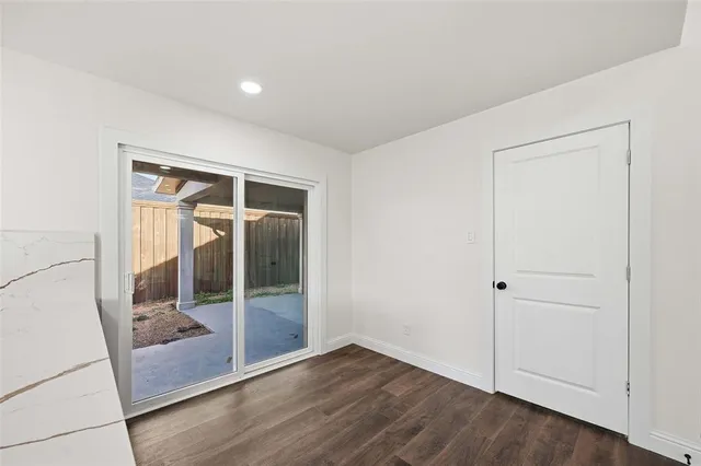 an empty room with wooden floor and mirror
