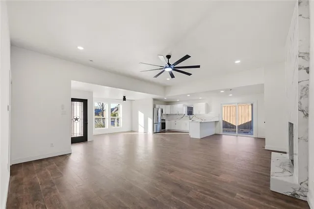 a view of an empty room and window with wooden floor