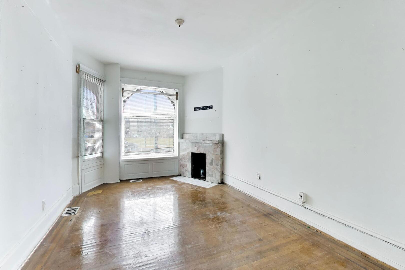 4505 South Indiana Avenue Chicago, IL 60653 - Photo 2 of 31 an empty room with windows and fireplace