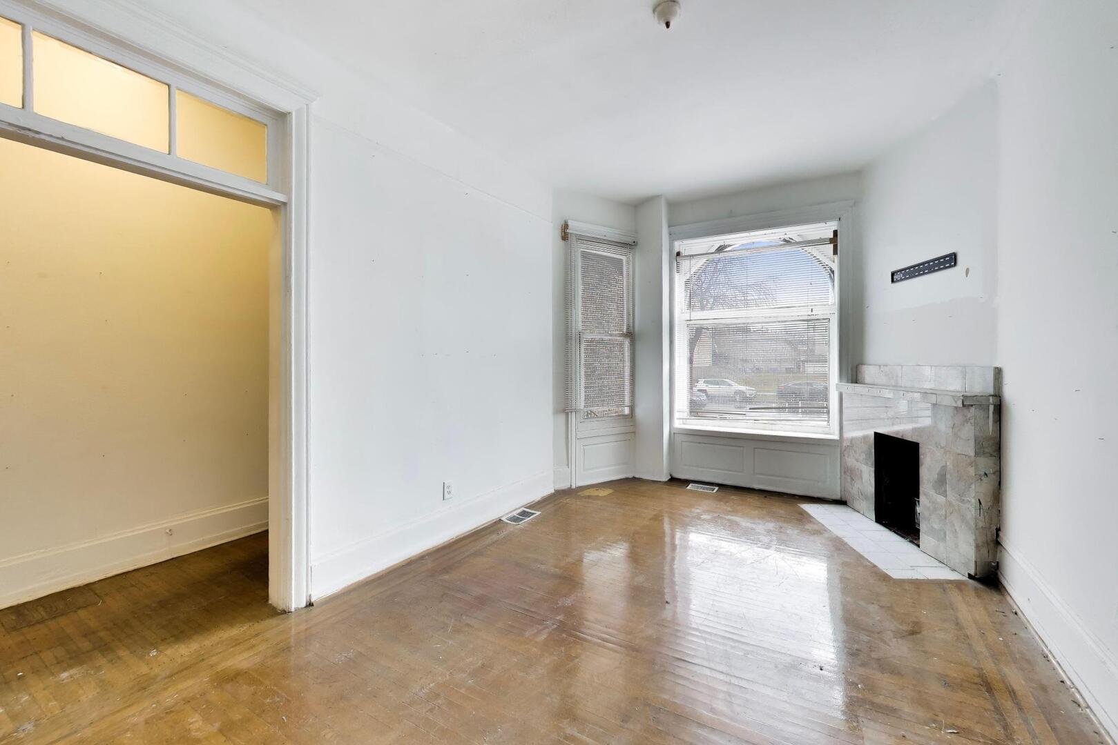 4505 South Indiana Avenue Chicago, IL 60653 - Photo 3 of 31 a view of an empty room with a window and wooden floor