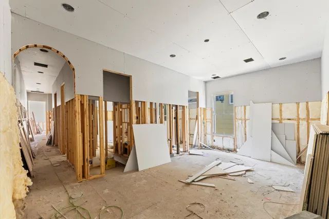 a view of a bedroom with wooden floor and windows