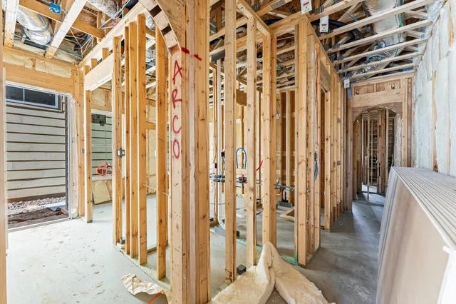 a view of a hallway with large mirror and cabinets