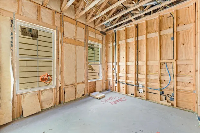a view of a hallway with a wooden door and staircase
