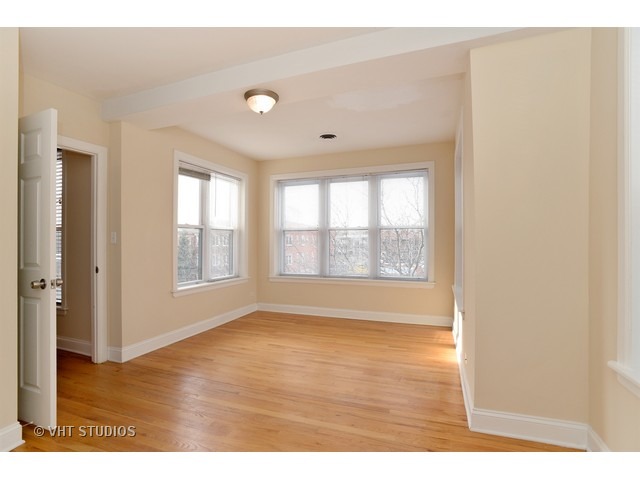 4105 North Sheridan Road, Unit 3N Chicago, IL 60613 - Photo 8 of 10 a view of an empty room with wooden floor and a window