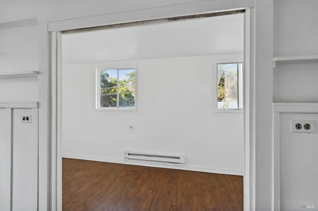 a view of a room with wooden floor and window