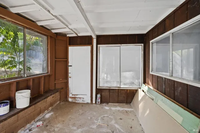 an empty room with a fireplace and large window