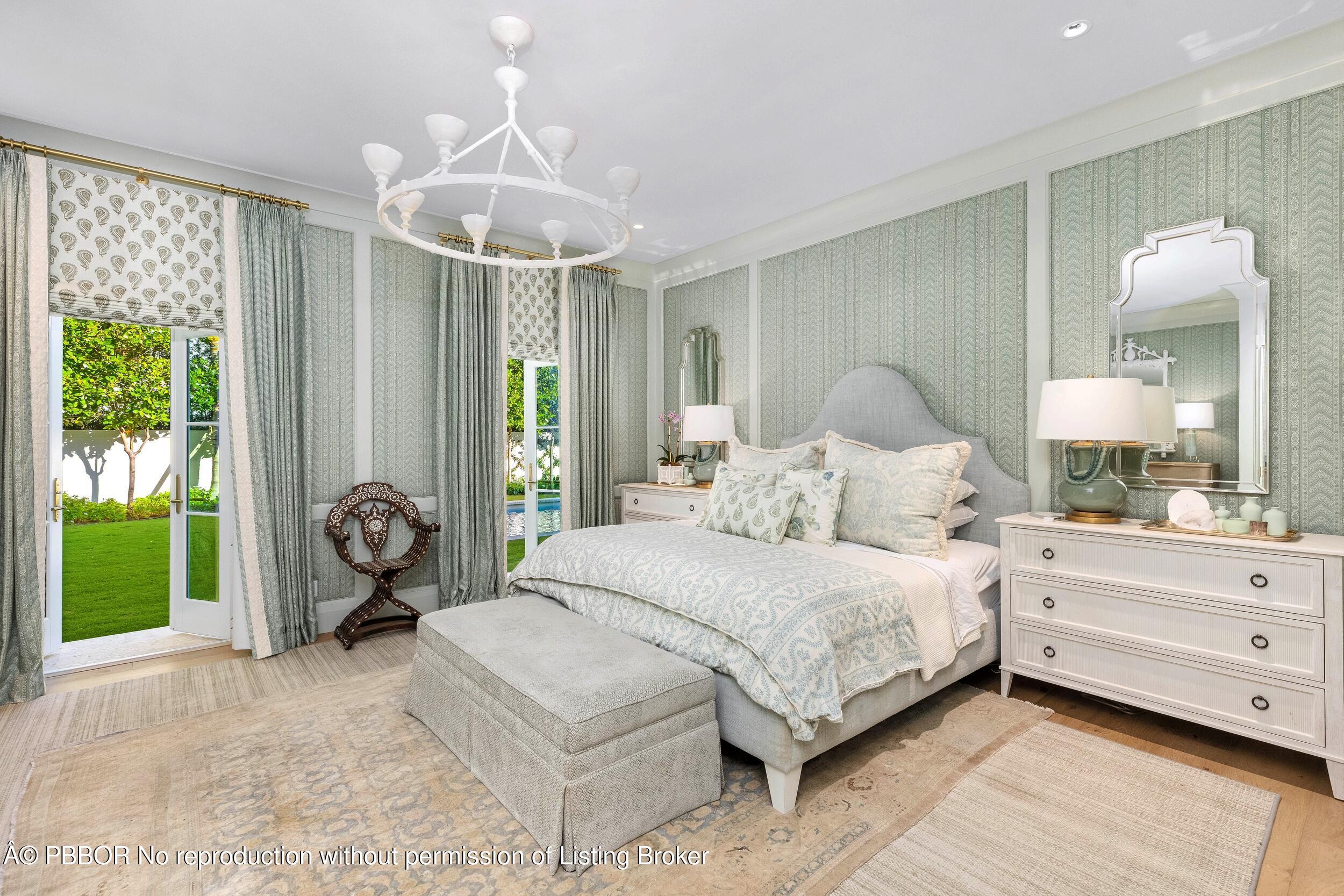 309 Chapel Hill Road Palm Beach, FL 33480 - Photo 23 of 50 a spacious bedroom with a bed and a chandelier