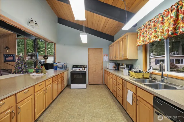 a kitchen with stainless steel appliances granite countertop a sink a stove and a wooden floors