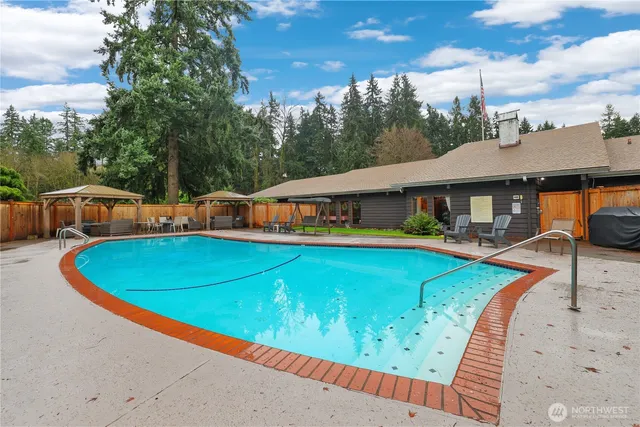 an aerial view of a house with pool and chairs