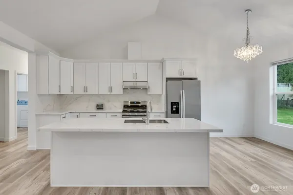a kitchen with kitchen island a counter space a sink stainless steel appliances and cabinets