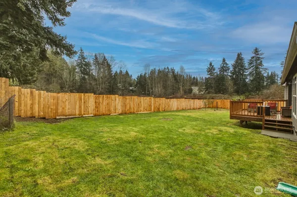a view of a yard with wooden fence