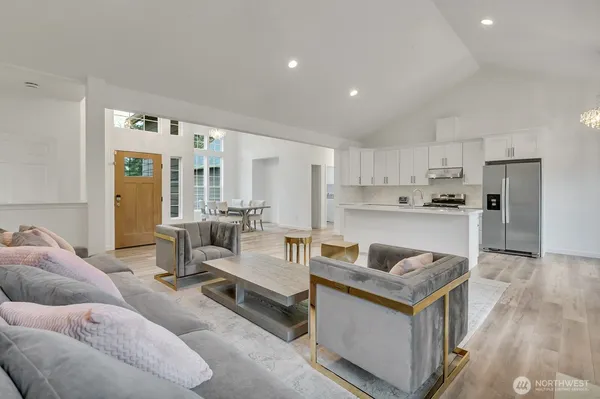 a living room with stainless steel appliances kitchen island granite countertop a couch and a view of living room