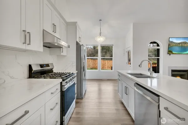 a kitchen with stainless steel appliances granite countertop a sink stove and cabinets
