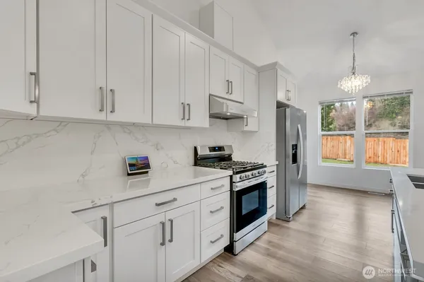 a kitchen with stainless steel appliances white cabinets and a window