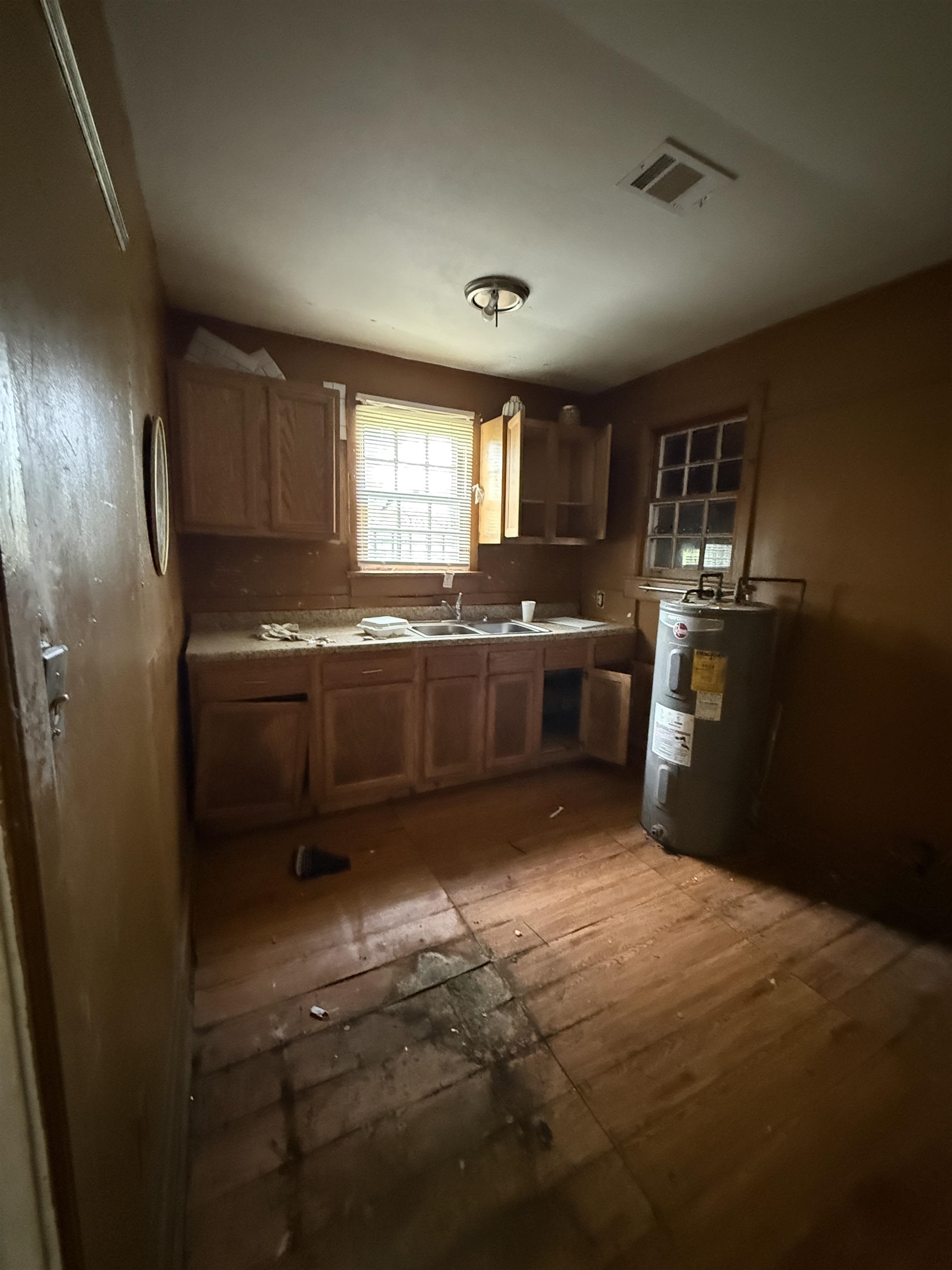 66 East Rollins Road Memphis, TN 38109 - Photo 27 of 31 Kitchen with water heater, light countertops, wood finish cabinets, and light wood-style flooring