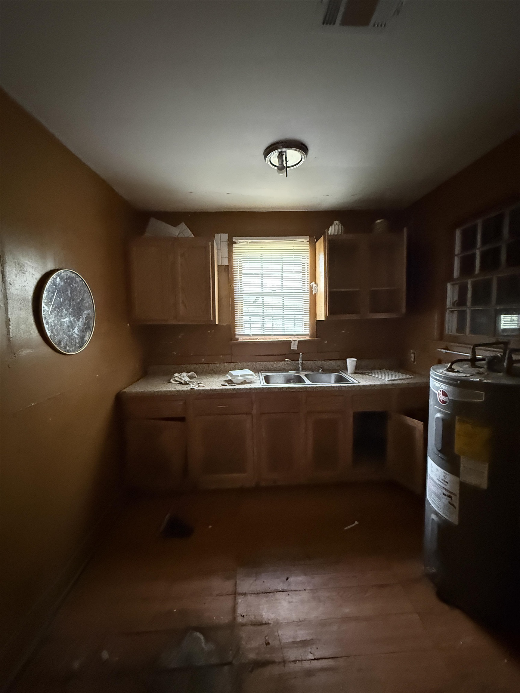 66 East Rollins Road Memphis, TN 38109 - Photo 30 of 31 Kitchen with water heater, dark wood-style flooring, wood finish cabinets, and light countertops