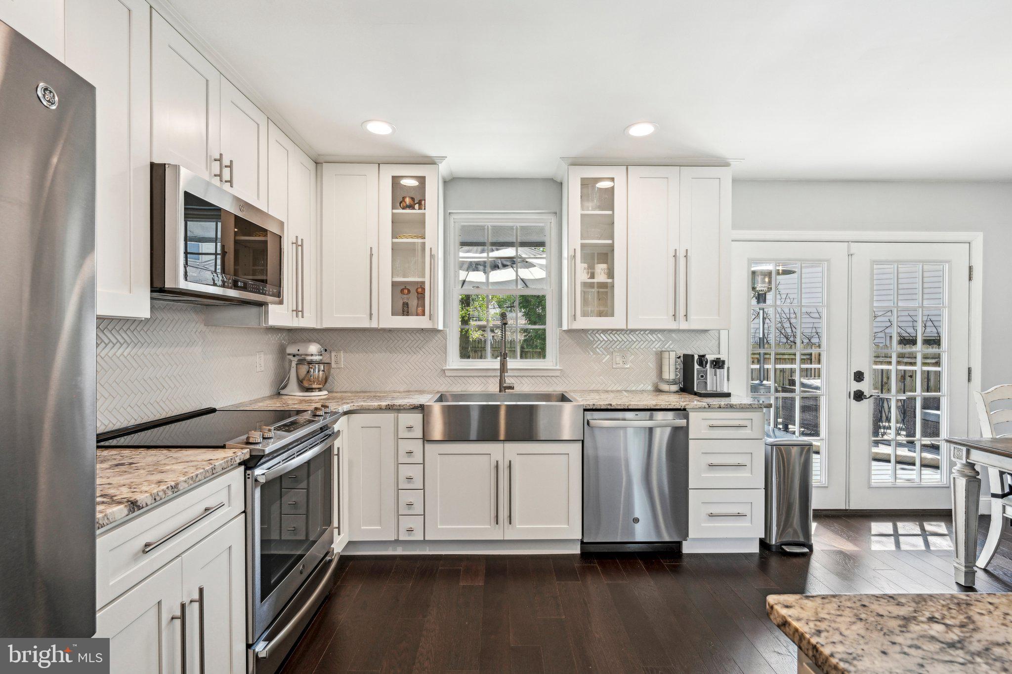 42 Cameo Road Claymont, DE 19703 - Photo 12 of 37 a kitchen with stainless steel appliances granite countertop a stove a sink dishwasher a refrigerator and white cabinets with wooden floor