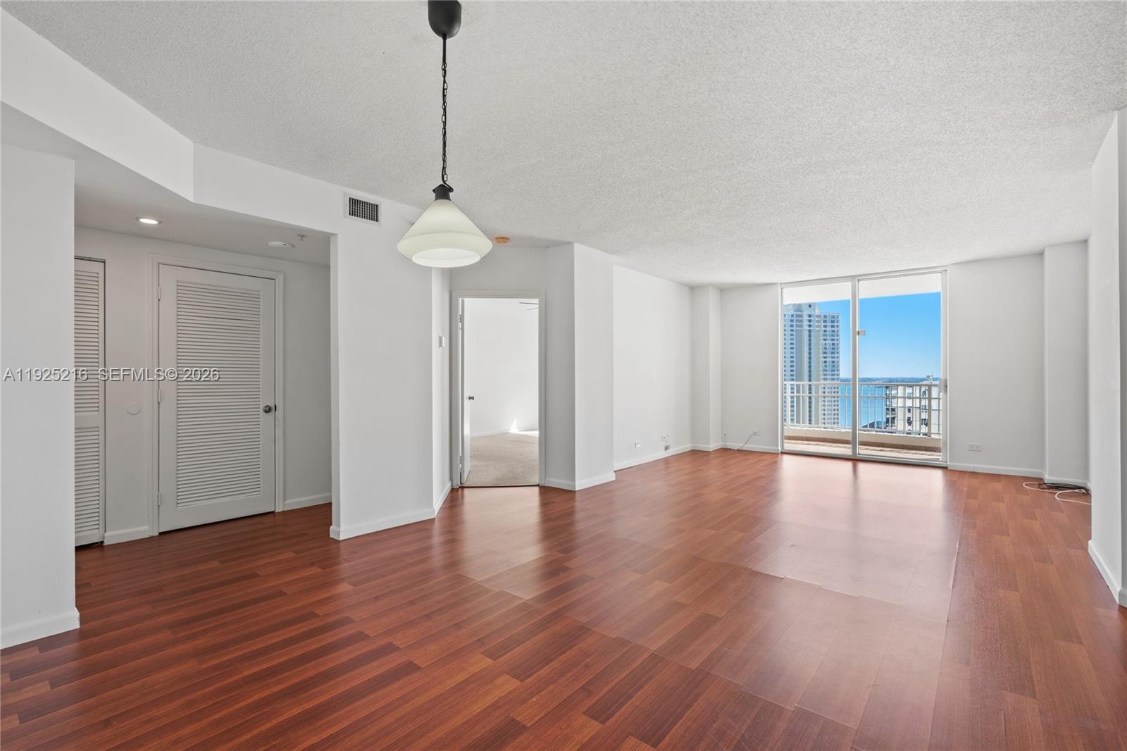 701 Brickell Key Boulevard, Unit 1911 Miami, FL 33131 - Photo 12 of 75 a view of empty room with wooden floor and window