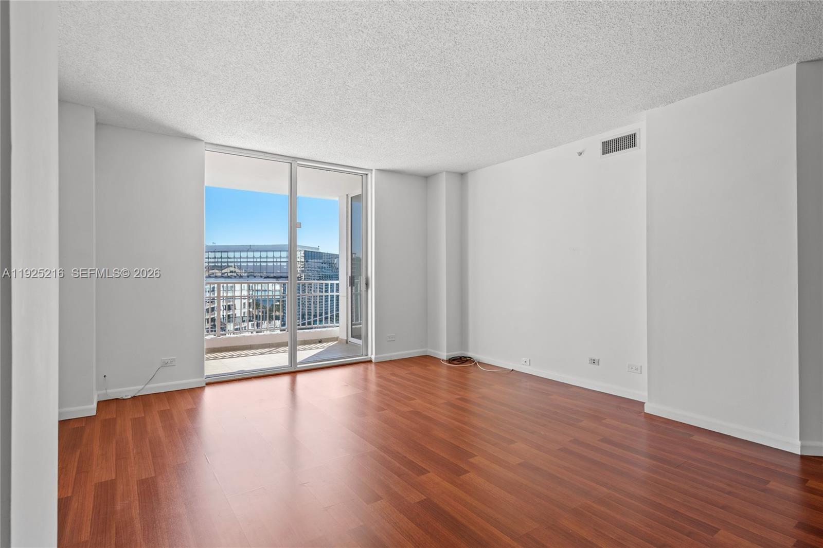 701 Brickell Key Boulevard, Unit 1911 Miami, FL 33131 - Photo 20 of 75 a view of an empty room with wooden floor and a window